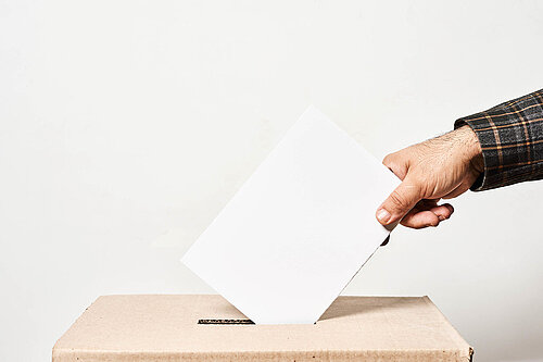 Person throwing a ballot in a box