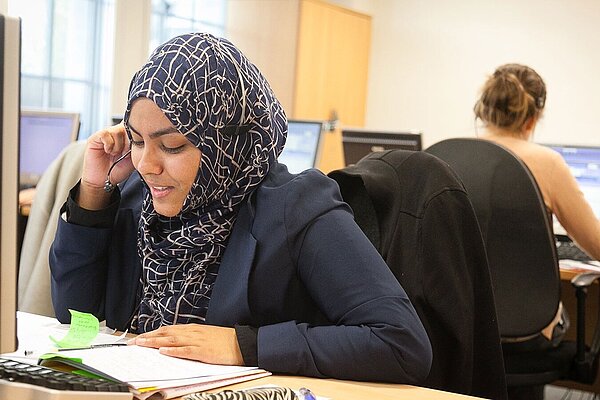 A lady in a call center talking into a headset.