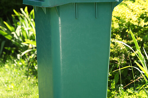 A wheelie bin overflowing with rubbish.